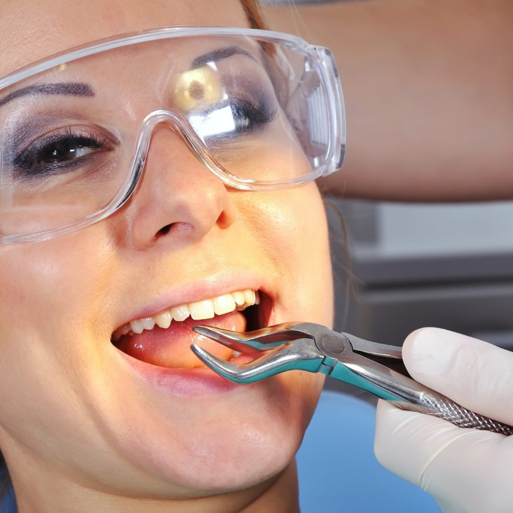 Patient in safety glasses during a tooth extraction